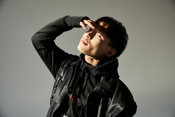Stylish young man striking a pose with confidence against a neutral background