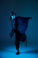 Stylish young man showcasing modern fashion against a vibrant blue backdrop