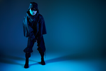 Handsome young asian man embodies stylish urban fashion in a striking blue lit setting