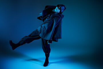 Stylish young man displays unique fashion in artistic blue light setting