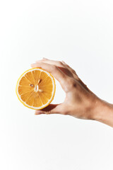 Hand holding an orange slice in front of a white background