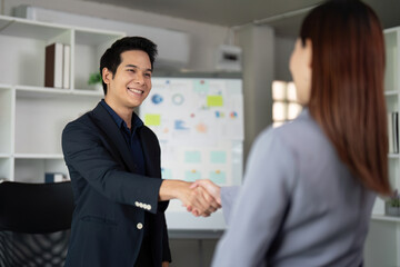 Networking and Professional Relations. A business associate exchanging a handshake in a modern office.