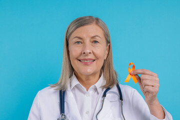 Multiple Sclerosis awareness. Doctor with orange ribbon on light blue background