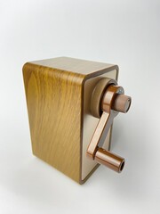 A close-up of a desktop pencil sharpener. The simple, functional design exudes a classic charm.