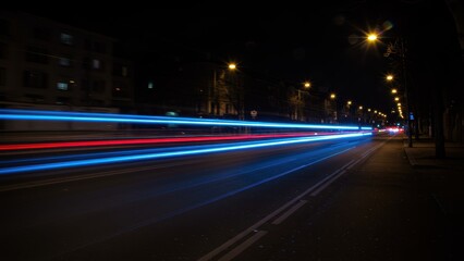 A long exposure captures light trails on a city street at night.