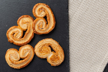 Delicious palmiers cookies lying on dark stone tray