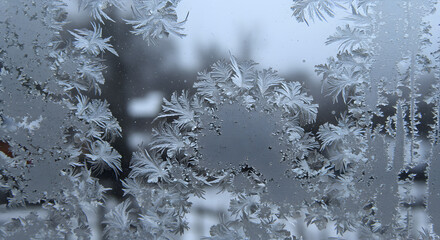 Intricate frost patterns on glass creating a wintery abstract design