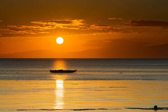 Serene Sunset Over Calm Ocean with Silhouette of Lonely Boat
