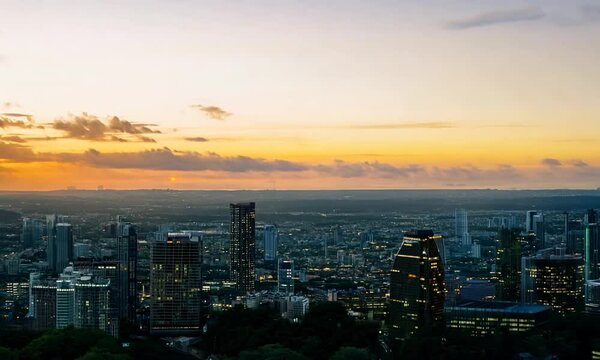 Sunset view over city skyline from rooftop with clouds and urban landscape