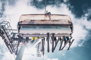 Ski lift system with skiers ascending snowy mountain slopes in Folgarida