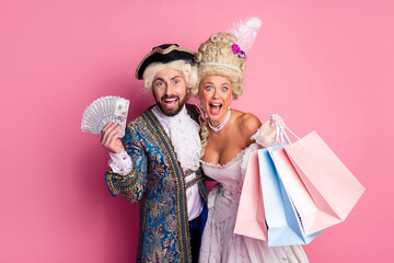 Elegant Couple in Royal Costumes Embracing Joyful Celebration Against Pink Background