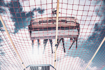 Ski lift with safety net and snow-covered mountain landscape in Folgarida