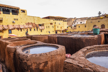 Tannery workers overseeing dye pits in a traditional leather tannery in Fes