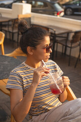 Young Indian woman enjoying a fruity drink in summer