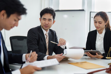 Law Firm Collaboration and Client Engagement. A group of lawyers engages in discussions while reviewing case documents and strategies.