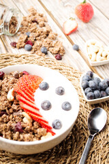 Muesli with organic berries and nuts. Oat muesli with raspberry, blueberry, strawberries, almond, cashew, banana. Healthy food, top view