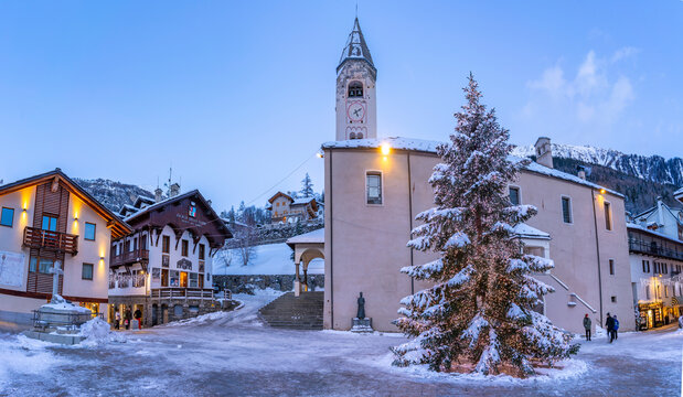 View of Christmas tree and Church of Saint Pantalon in Piazza Abbe Henry at dusk, Courmayeur, Aosta Valley, Italian Alps