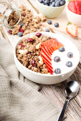 Muesli with organic berries and nuts. Oat muesli with raspberry, blueberry, strawberries, almond, cashew, banana. Healthy food, top view