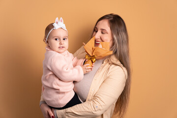 joyful mom and baby with easter egg in all beige colors. holiday, easter, celebration concept.