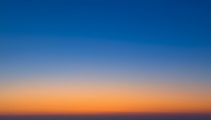 Fototapeta premium 深い青から暖かいオレンジに変わるグラデーションの夕焼け空