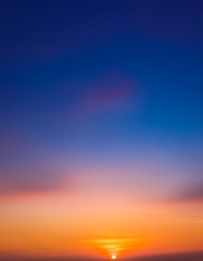 深い青から暖かいオレンジに変わるグラデーションの夕焼け空