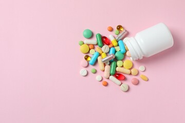 Various pills with white bottle on color background, top view