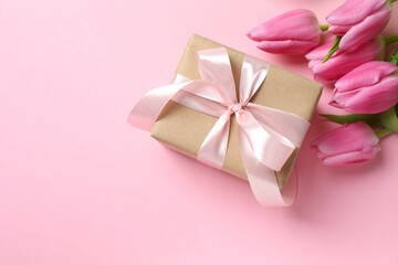 Happy Mother's Day. Beautiful bouquet of fresh tulips and gift box on a colored background