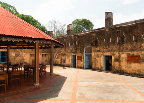 Traditional banda with red roof and old building in a courtyard in zanzibar, tanzania, africa