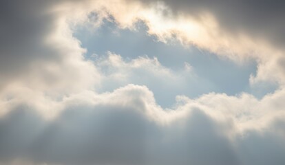 Obraz premium Dramatic clouds with sunlight breaking through vast blue sky create serene, moody atmosphere for nature appreciation.