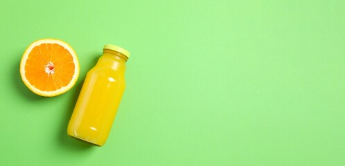 Bottle of freshly squeezed orange juice with citrus fruit on a color background © Sunlight