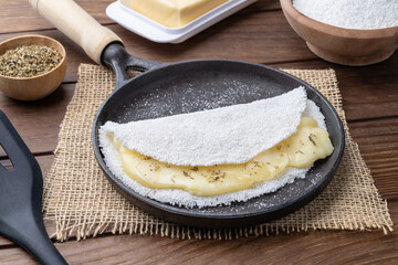 Traditional brazilian cheese stuffed tapioca on a pan with ingredients