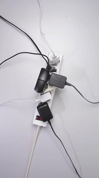 Electric adapter power plug has many appliances are plugged outlet socket. Electrical overload. Overloaded power plugs, close - up