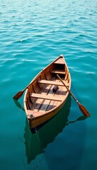 Obraz premium A basic wooden rowboat with oars drifting on calm blue water, calm, wooden