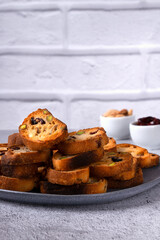 Rusks with dried cranberries and pistachios in a ceramic bowl on a light background