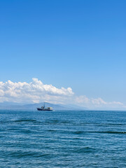 Boat Sailing Across the Calm Blue Sea and Sky