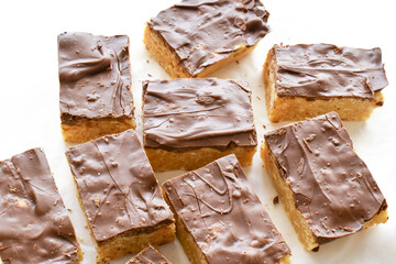Chocolate caramel rice crispy treats on parchment paper.