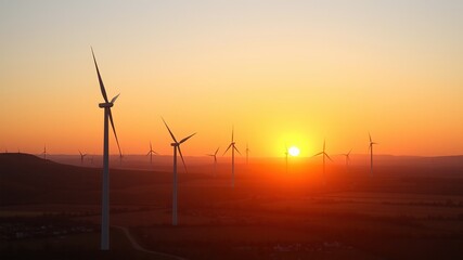 Obraz premium Golden Sunset Over Wind Farm and Village
