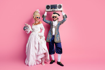 Elegant Couple Wearing Royal Costumes at a Vintage Party with a Pink Backdrop