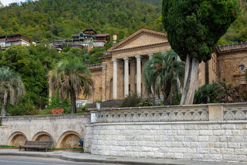 Fototapeta premium Gagra, Abkhazia-October 11 2024 : Old historical building with columns among the mountains in the Republic of Abkhazia. Building of the Winter Theater in Gagra. Sunny autumn day