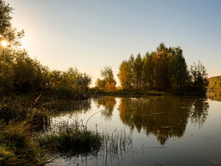Fototapeta premium River landscape on a sunny autumn morning. The serenity and tranquility of an autumn morning on the banks of a narrow rural river.