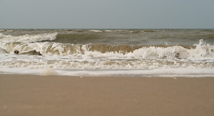 Enjoy the serene calm waves gently lapping against the soft sandy shore near the ocean