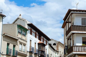 Beautifully preserved buildings line a narrow street in a historic village in Spain