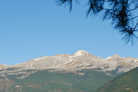 majestic mountain range is visible in the distance, featuring snow-covered peaks