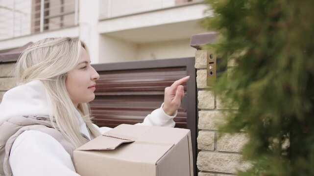 Woman delivering a package and ringing the doorbell at a residential home in a quiet neighborhood