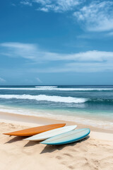 Obraz premium Bright surfboards resting on sandy beach by the ocean under a clear blue sky