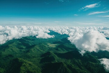 Obraz premium Lush green mountains under a vast blue sky, partially covered by fluffy white clouds