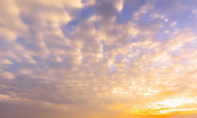 Obraz premium Beautiful view of a blue sky with clouds at sunrise, featuring a cinematic blend of yellow and white hues. Perfect for social media post designs and natural sky backgrounds.