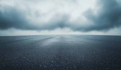 Driving on Asphalt Road Under Overcast Sky with Dramatic Clouds