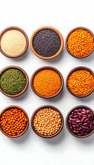 Nine bowls of various dried legumes and seeds on white background