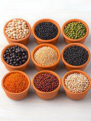 Nine bowls of assorted legumes and grains on white wood